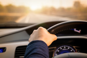 driver keeps one hand on steering wheel