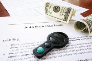 auto insurance policy with money and keyfob