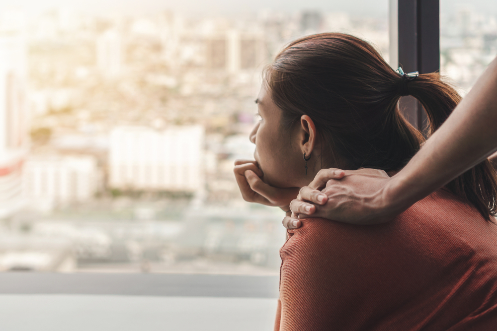 woman looks out window