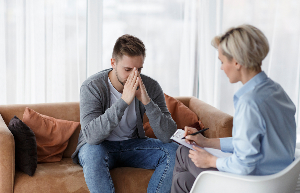 man with ptsd talks to therapist