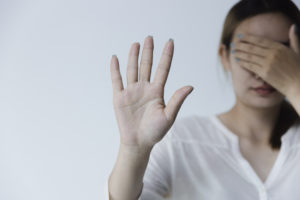 woman covers eyes and holds out hand