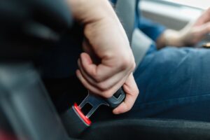 Driver-putting-on-seat-belt-before-driving-in-car