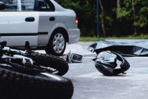 A motorcycle lies in the middle of a Chesapeake road after a collision with a car. A motorcycle accident attorney near Chesapeake can assist with any necessary legal action.