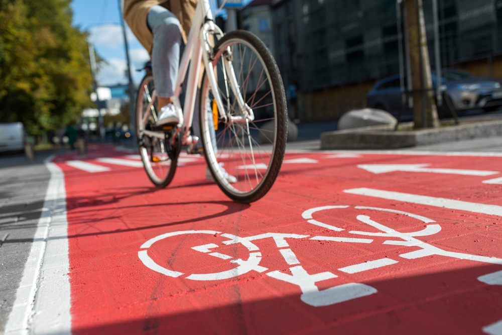 Woman cycling along a bike lane as she wonders about the 12 questions to ask her bicycle accident lawyer.