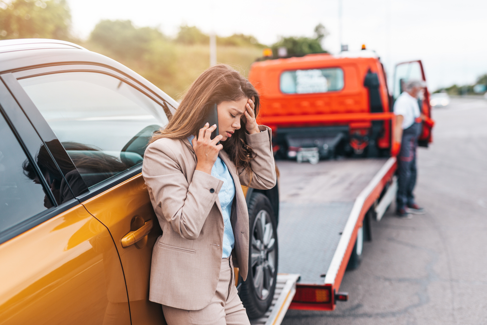 A woman on the phone as her car is being towed. How long does an accident stay on your record in Virginia?